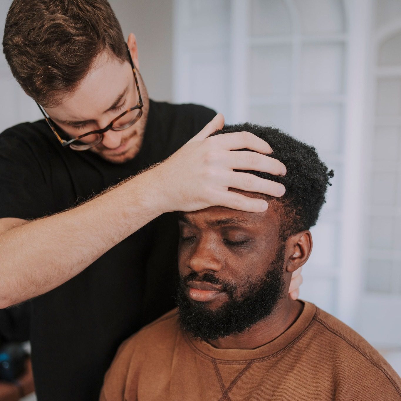 Dr. Francisco Turelli checking a practice member's neck before a chiropractic adjustment at illumINNATE Chiropractic Studio, Barcelona