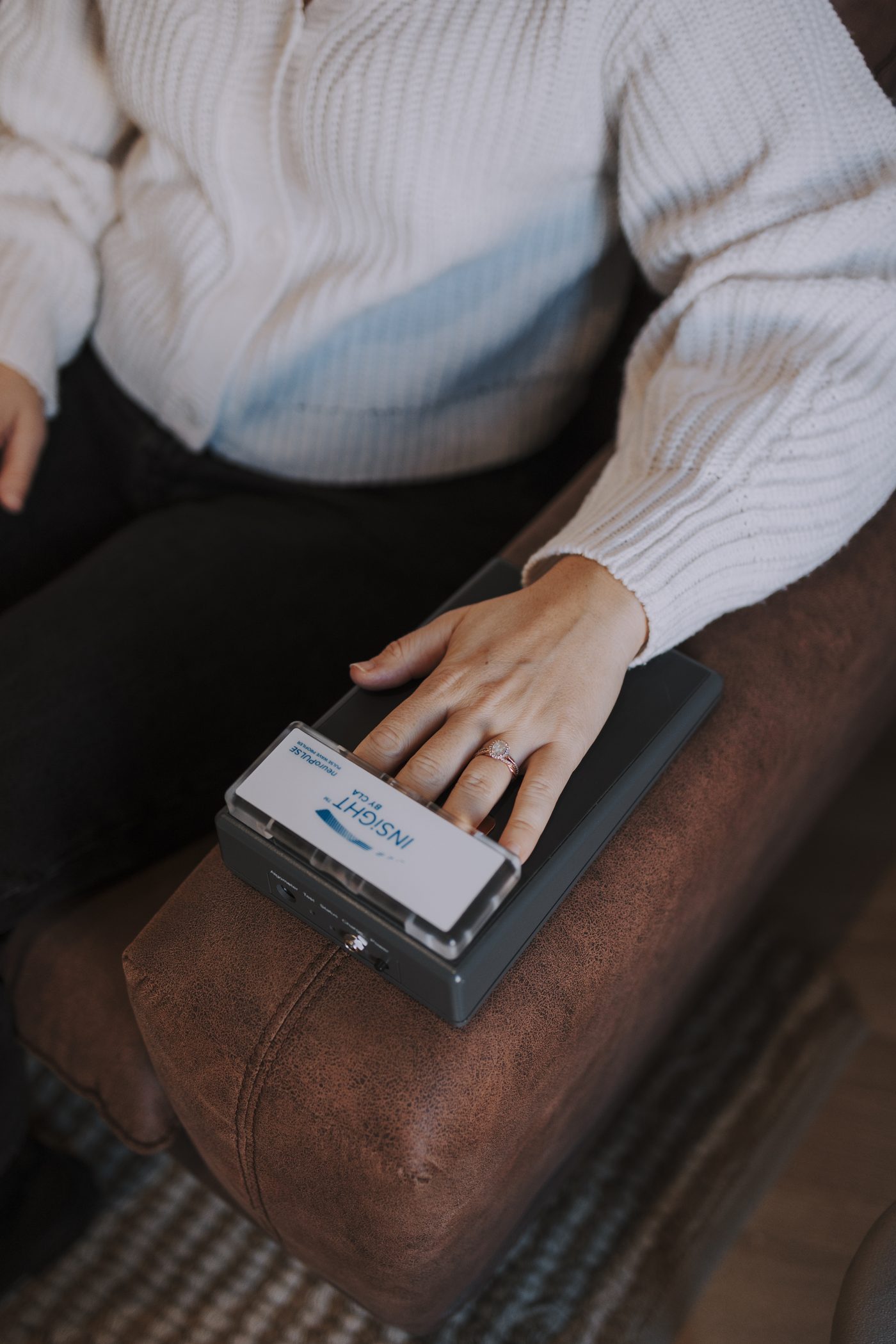 La mano de un paciente sobre el sensor INSiGHT de variabilidad de la frecuencia cardíaca durante un escaneo del sistema nervioso en illumINNATE